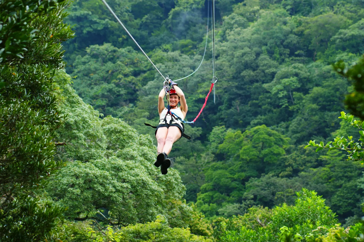 Smiling woman ziplining on the Buena Vista combo tour at Rincón de la Vieja, Costa Rica