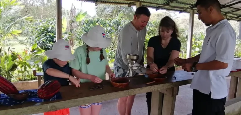 Family grinding cacao by hand with their guide on a chocolate tour in Costa Rica