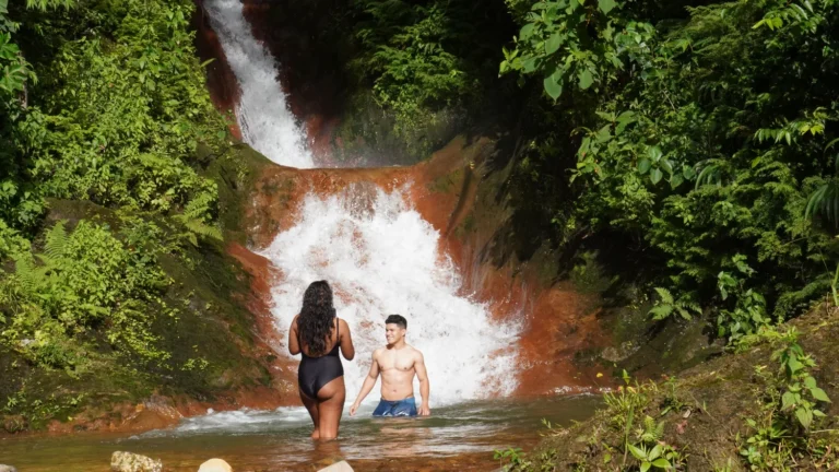 Couple bathing in a natural pool at the base of a waterfall on a Guanacaste waterfall tour