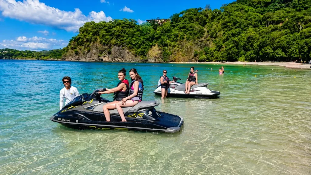 Guide and riders on jet skis in the shallows of a Guanacaste beach, Costa Rica