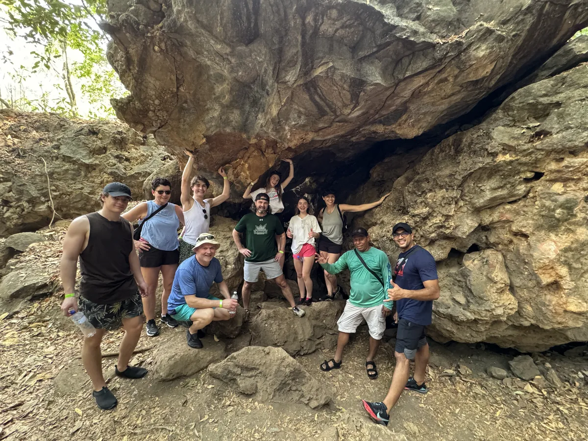 Tour group at a rock cave along the La Leona waterfall trail in Guanacaste, Costa Rica