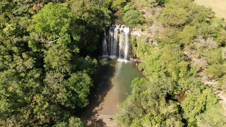 Aerial view of Llanos de Cortés waterfall and pool in the dry forest — Guanacaste waterfall tour, Costa Rica
