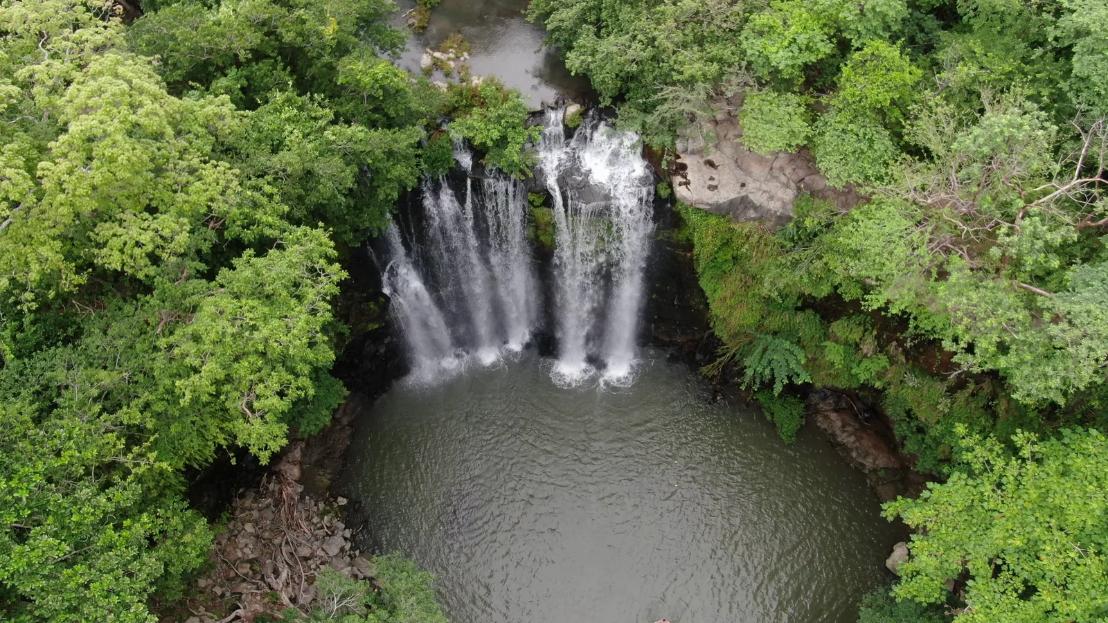Top-down aerial of Llanos de Cortés waterfall and its swimming pool, Guanacaste, Costa Rica