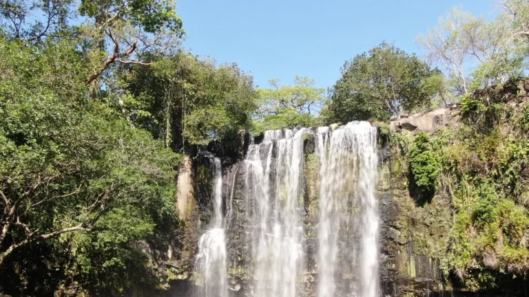 Llanos de Cortés waterfall framed by tropical dry forest — Guanacaste waterfall tour, Costa Rica