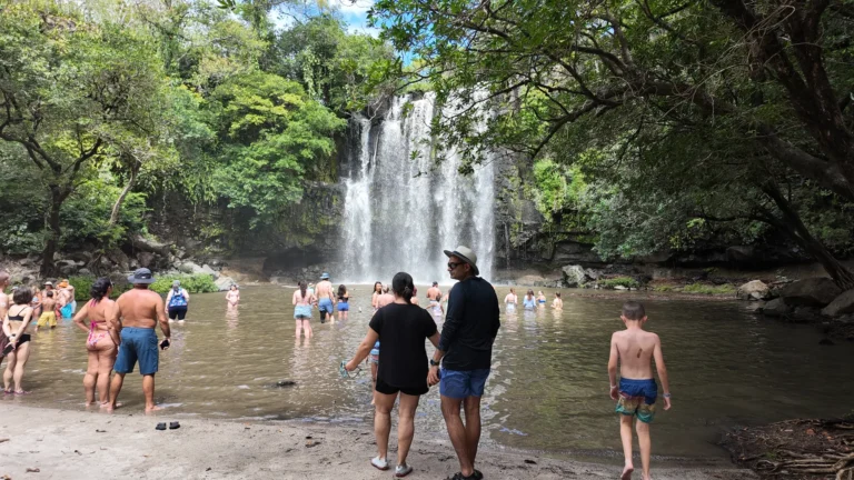 Visitors swimming below Llanos de Cortés waterfall on a Guanacaste tour