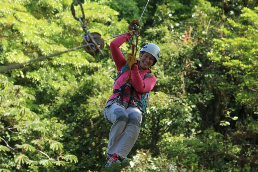 Guest ziplining through the green Monteverde cloud forest canopy