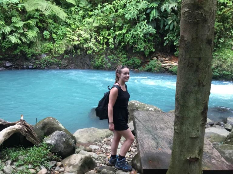 Guest beside the vivid blue Río Celeste on a private nature tour in Costa Rica