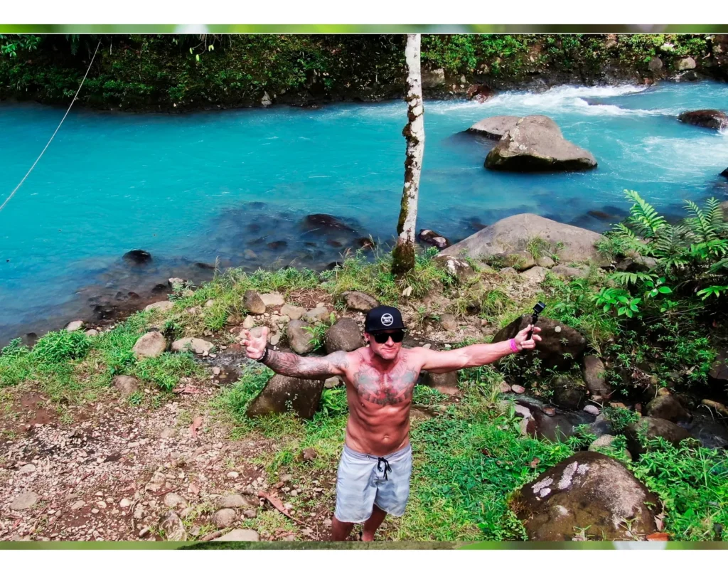 Guest by the bright turquoise Río Celeste on a private blue river swimming tour