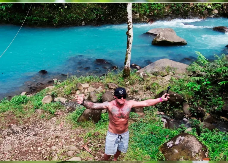 Guest by the bright turquoise Río Celeste on a private blue river swimming tour