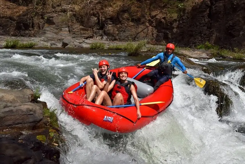 Rafters dropping a small waterfall on a Tenorio River rafting tour