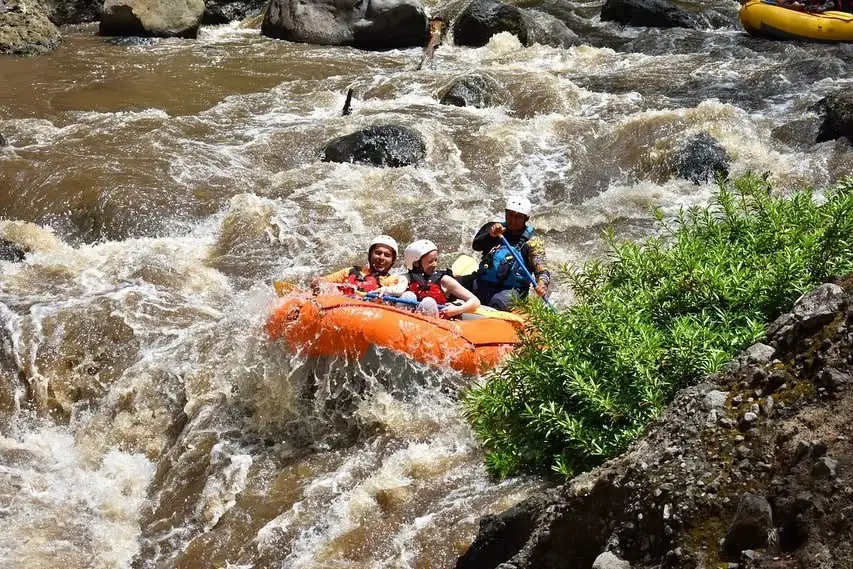 Family rafting past rocks on the Tenorio River, Guanacaste