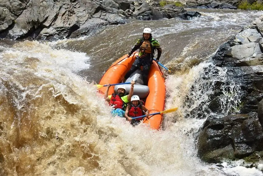 Orange raft dropping a waterfall, Tenorio River white water rafting