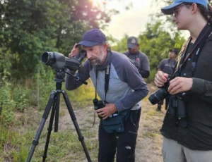 Guide with a spotting scope helping a photographer, Costa Rica