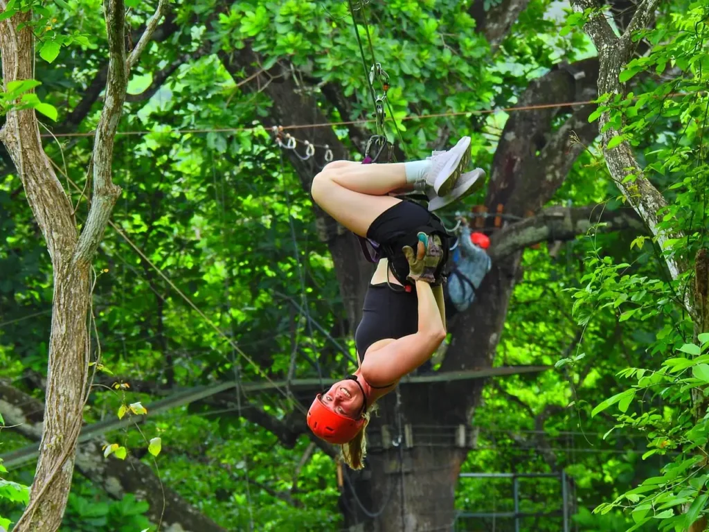 Woman zip lining upside down on an adventure canopy tour in Guanacaste, Costa Rica