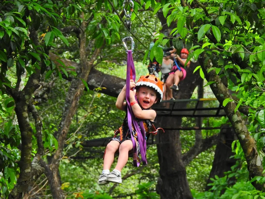 Young boy smiling while zip lining on a canopy tour in Guanacaste, Costa Rica