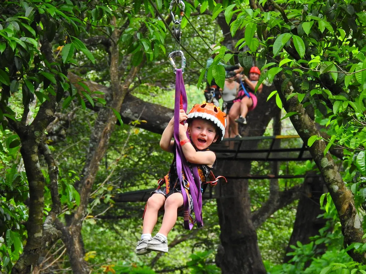 Young boy smiling while zip lining on a canopy tour in Guanacaste, Costa Rica