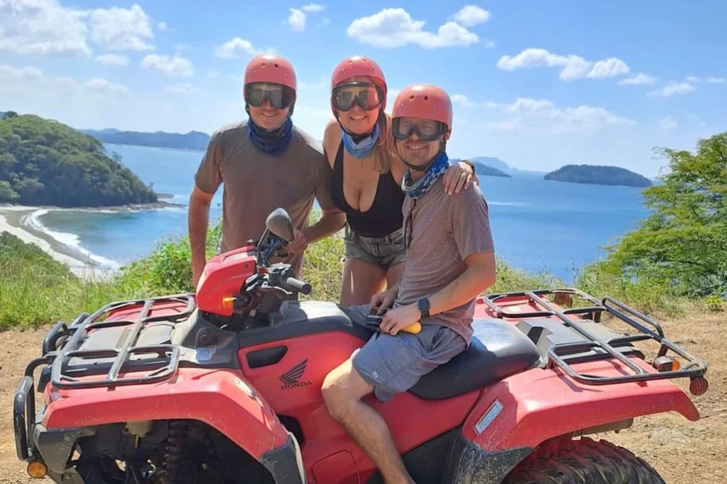 Three friends on an ATV at a Pacific coast viewpoint on a Guanacaste ATV tour