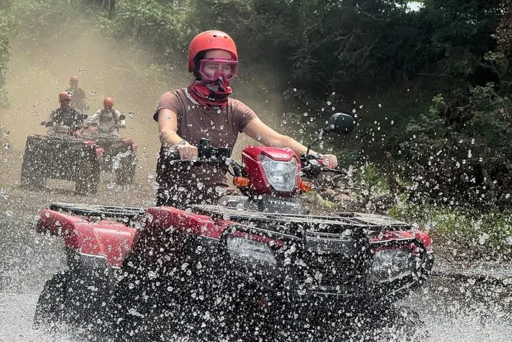 ATV rider splashing through a river crossing on a Guanacaste off-road tour
