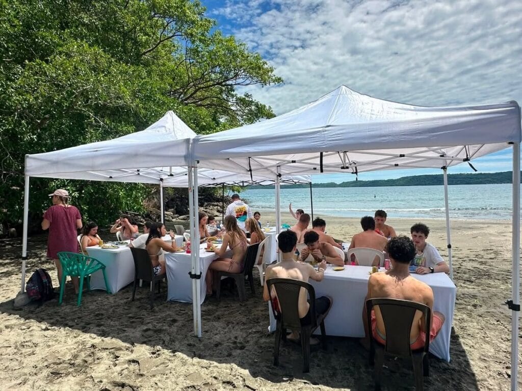Beach barbecue spread with fresh fruit and salads set up under shade tents on a secluded beach in the Gulf of Papagayo, Guanacaste, Costa Rica