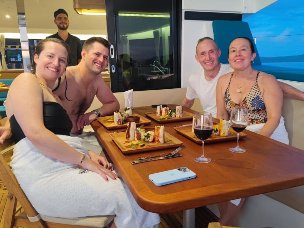 Guests at a dinner table on deck during a sunset sail in the Gulf of Papagayo, Guanacaste, Costa Rica