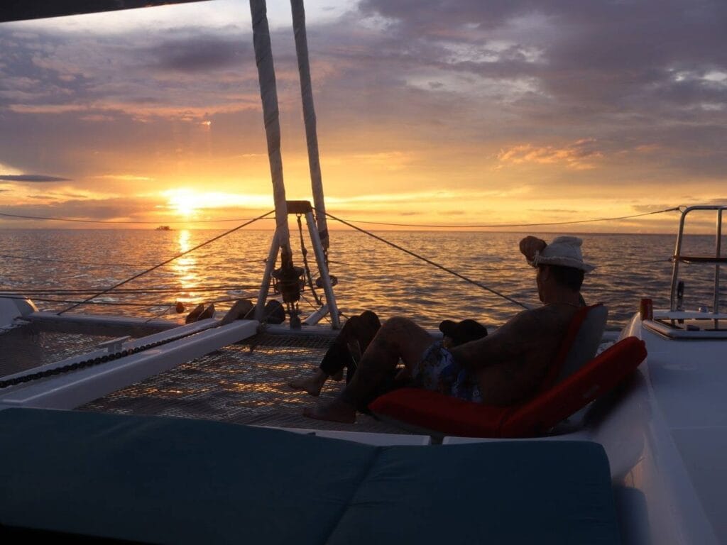 Guests relaxing on the bow during a sunset sail in the Gulf of Papagayo, Guanacaste, Costa Rica