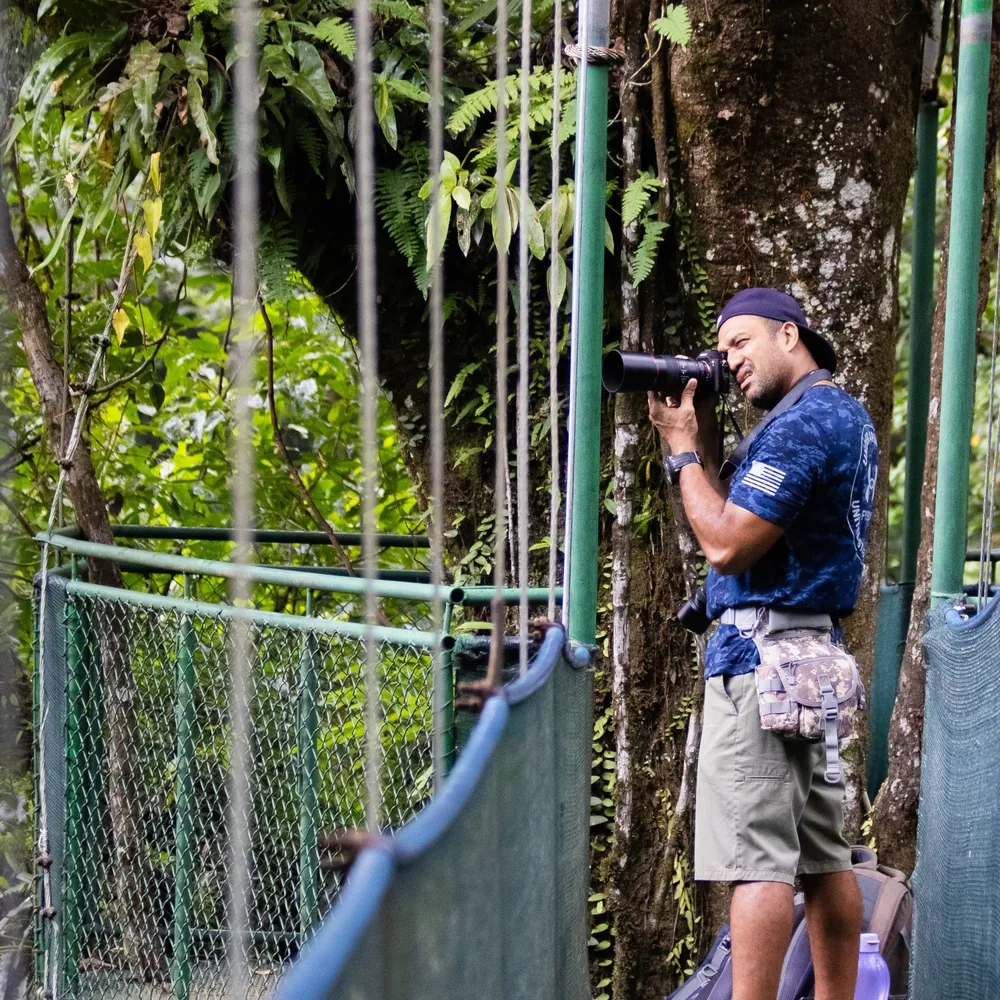 Miller Contreras, founder and lead naturalist guide, with a telephoto lens on a canopy platform in the Tenorio rainforest