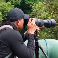 Miller Contreras photographing wildlife with a telephoto lens from a raft in Costa Rica
